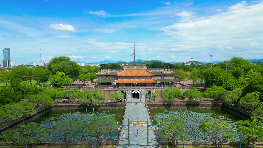 aAerial view of the Meridian Gate in Hue Imperial City, showcasing vibrant greenery and the surrounding architecture under a clear sky.