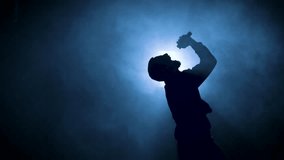 Silhouette of a man singing with a microphone at a concert. Singer artist performing. High quality 4k footage - Powered by Shutterstock - Get 15% off with code: PIKWIZARD15