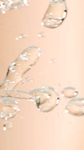 Macro shot of various air bubbles rising up on beige background. Slow motion.