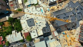 Top view towering crane at construction site.  Aerial view captures ongoing construction work in a bustling urban environment. A large crane dominates the skyline while workers and machinery are busy  - Powered by Shutterstock - Get 15% off with code: PIKWIZARD15