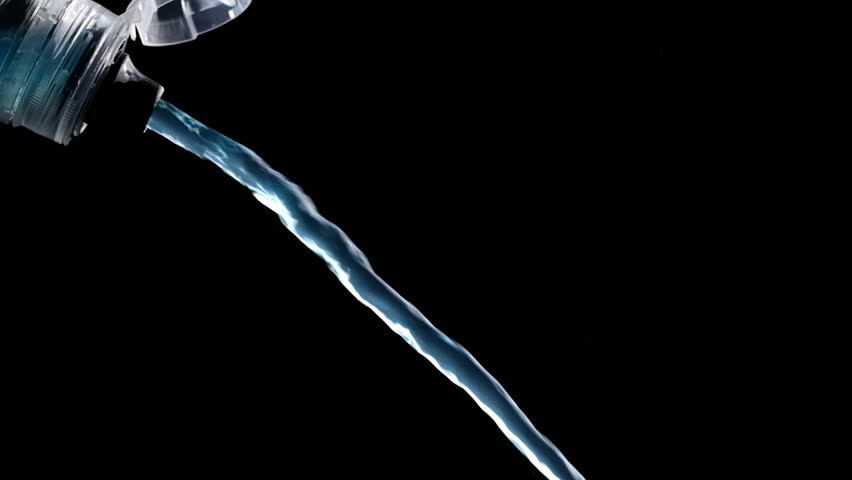 Blue Isotonic Sport Water Pours From The Bottle, With Drops And Splashes Captured In Slow Motion