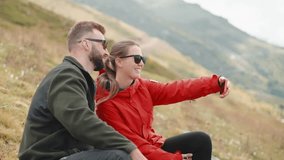 happy hikers taking selfie by smartphone on slope of mount during halt, joyful smiling man and woman resting after hiking and climbing at top, sportive and active leisure in nature - Powered by Shutterstock - Get 15% off with code: PIKWIZARD15