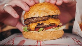 Juicy freshly cooked cheeseburger close-up, hungry man picks up the burger. High quality 4k footage - Powered by Shutterstock - Get 15% off with code: PIKWIZARD15