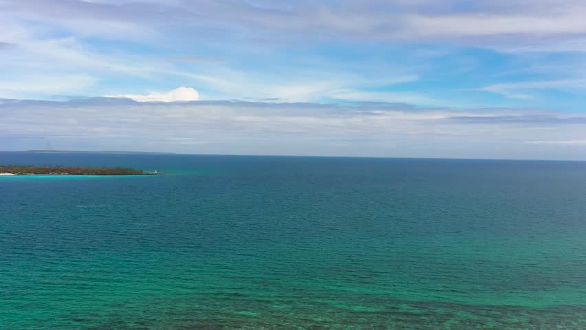 Blue sea and corals in Bantayan. Virgin Island with sandy beach. Blue sky and clouds. Cebu, Philippines.