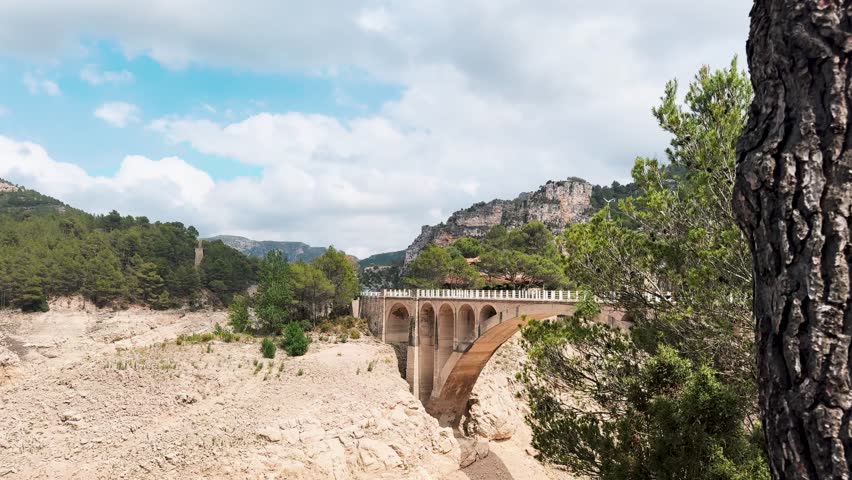 A reservoir with azure water in the mountains of Spain, a trail near Montanejos, Castellon. A dam covers the river for safety during heavy rains. A popular place for active recreation. The Arenos