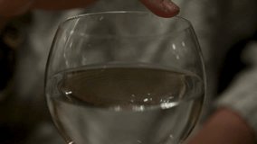 A woman rubs her finger on the rim of a delicate wine glass, producing calm and satisfying patterns in the water. - Powered by Shutterstock - Get 15% off with code: PIKWIZARD15