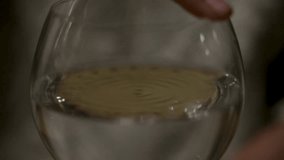 A woman rubs her finger around the rim of a wine glass producing lots of waves from the vibrations. - Powered by Shutterstock - Get 15% off with code: PIKWIZARD15