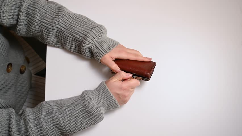 Empty wallet without money. Female hands open a wallet and looking for money