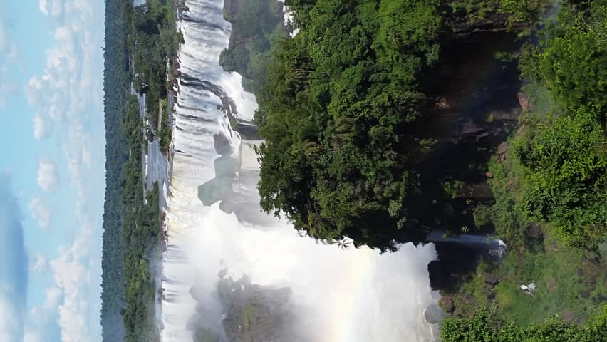 Popular Iguazu Falls In Summer With Rainbow In Brazil And Argentina Border. - aerial vertical shot