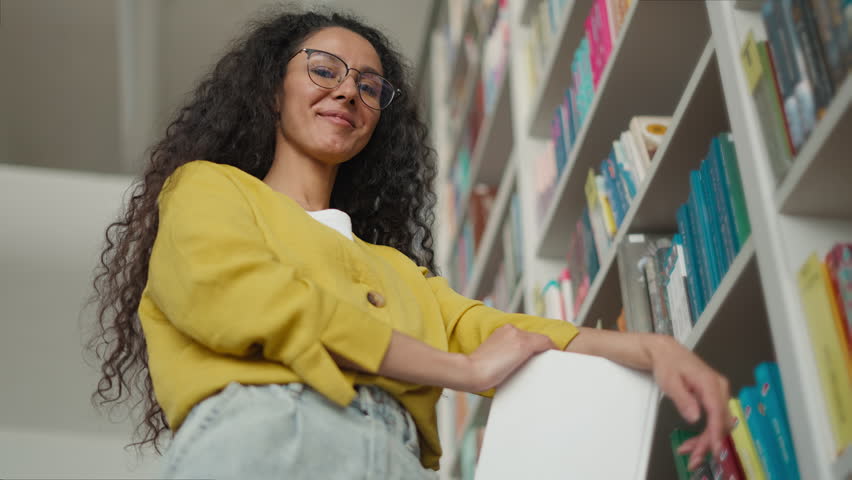 Happy student Hispanic Caucasian Latino woman library high school university college studying female learning looking at camera smiling girl education bookstore teacher client customer campus academy