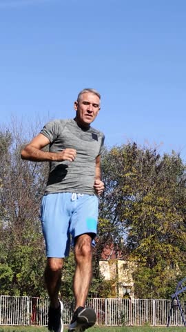 Middle-Aged Man Performing High Intensity Interval Training - Running Workout on Grass. During the exercise effort and sweat are visible on his face. Ideal for promoting fitness in middle-age men.
Series Code: FitMature54Series2024
This clip is part of a dedicated series featuring a fit, middle-aged man in his 50s performing various outdoor exercises. Explore the full collection to find matching shots of jogging, pushups, dips, core workouts, and HIIT sprints for a consistent visual story.