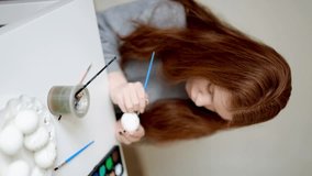 red hair girl paints easter eggs. Vertical video - Powered by Shutterstock - Get 15% off with code: PIKWIZARD15