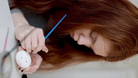 red hair girl paints easter eggs. Vertical video - Powered by Shutterstock - Get 15% off with code: PIKWIZARD15
