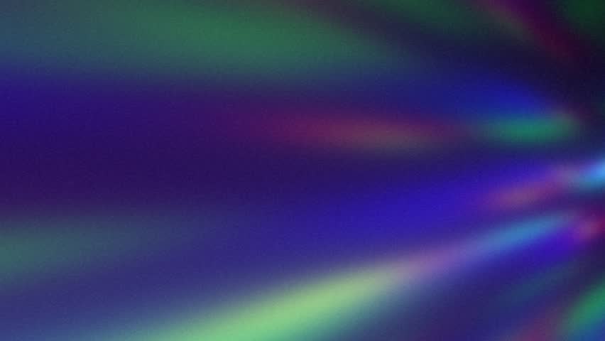 Defocused rainbow-colored rays of light. Flow of disco ball reflections. Prismatic blurred grainy motion background. Abstract spectrum beams in acid green magenta pink blue violet colors. Party vibes