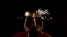 Two Champagne Glasses Clinking and Toasting Under a Dark Sky Lit by Fireworks on New Year's Eve, Festive and Celebratory Mood, party cheers with sparkling bubbles and golden reflections - Powered by Shutterstock - Get 15% off with code: PIKWIZARD15