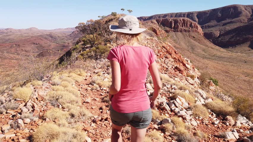 Woman trekking at Ormiston Pound Walk in West MacDonnell Ranges. Mount Sonder lookout, one of highest mountains in Northern Territory, Australia Outback.