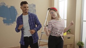 Man and woman dancing playfully in a newly renovated room with painted walls and moving boxes, symbolizing a joyful couple celebrating a new home experience together indoors. - Powered by Shutterstock - Get 15% off with code: PIKWIZARD15