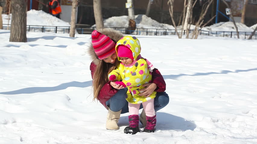Happy mother with her daughter in winter outside