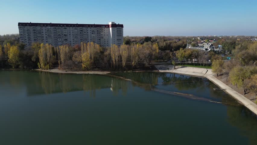 An urban lake and various apartment buildings and a road.