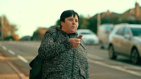 Woman eating chocolate bar near residential street. Old female enjoying sweet snack outdoors close to suburban area. Senior lady having treat beside quiet neighborhood road - Powered by Shutterstock - Get 15% off with code: PIKWIZARD15