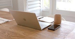 Laptop, smartphone, notebook, and coffee mug on wooden table in home office. Remote working, technology, productivity, workspace, freelance, digital nomad - Powered by Shutterstock - Get 15% off with code: PIKWIZARD15