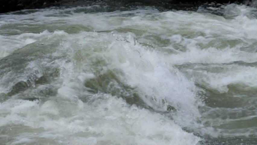 Slow motion of water flowing in a river cascade.River in the mountains.River with fast current.Footage 4K,24Fps