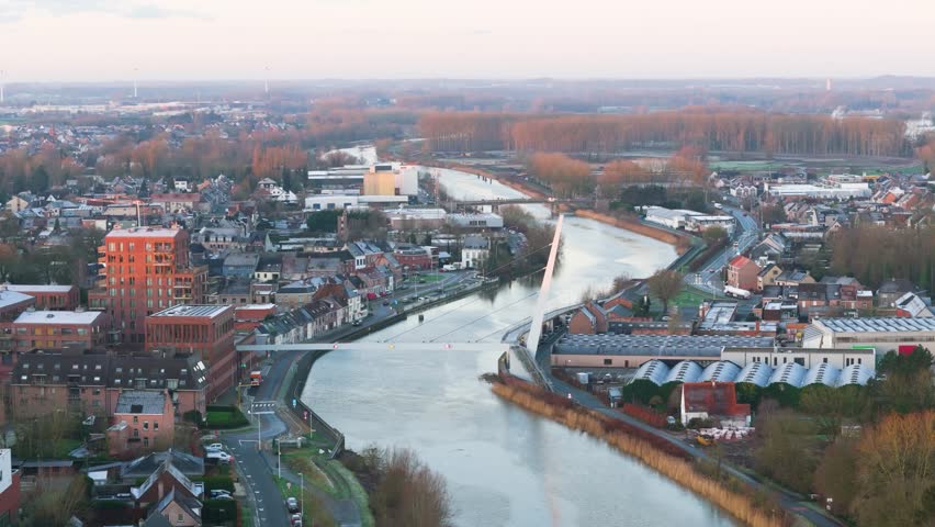 city hall bridge over scheldt river wetteren belgium beautifully illuminated by sunrise creating picturesque scene town aerial footage visuals architecture light serenity