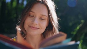 Romantic woman reading book at sunshine park closeup. Young beautiful lady holding flower flipping pages at serene greenery nature. Feminine gentle model resting summer landscape enjoying novel alone  - Powered by Shutterstock - Get 15% off with code: PIKWIZARD15