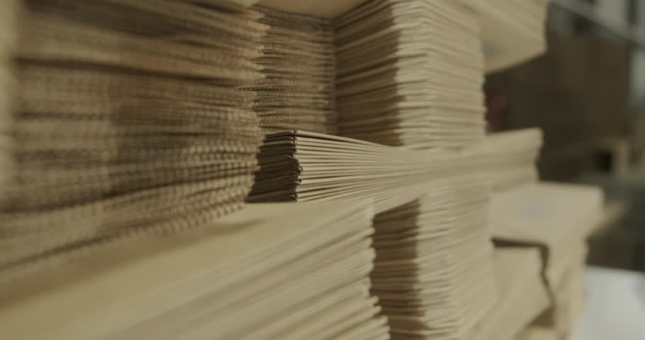 Close-up view of neatly stacked kraft paper bags in a manufacturing facility, showcasing eco-friendly packaging production and industrial precision
