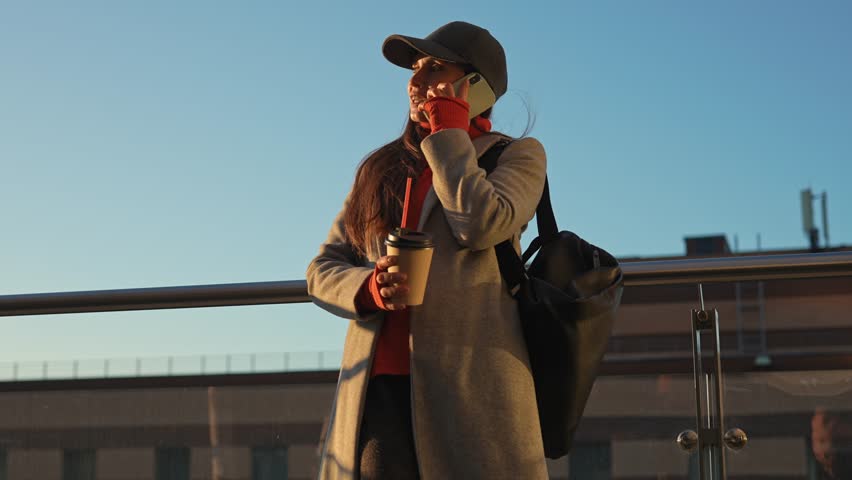 Stylish woman in autumn casual clothes talking on a smartphone