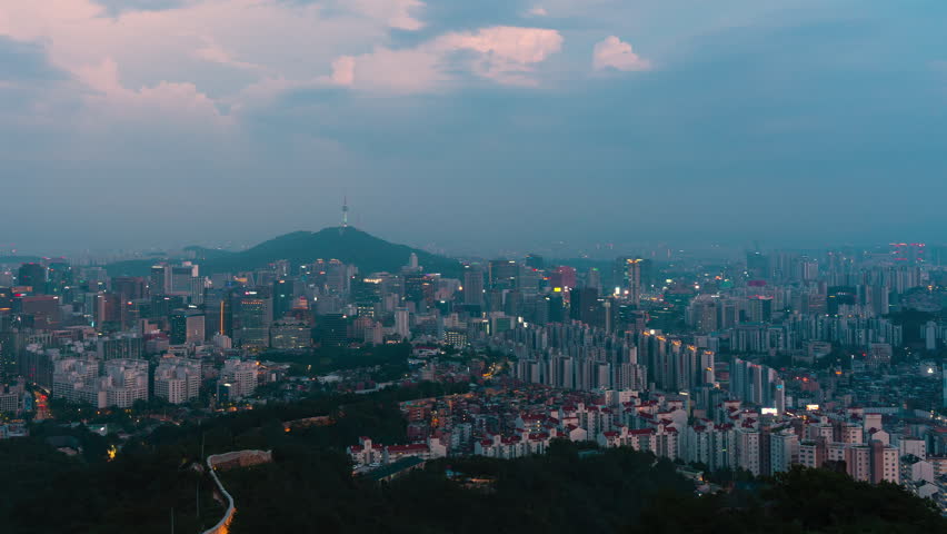Seoul Cityscape with Namsan N Seoul Tower During Blue Hour with Thunder Flashing in Clouds, South Korea - panning hyperlapse