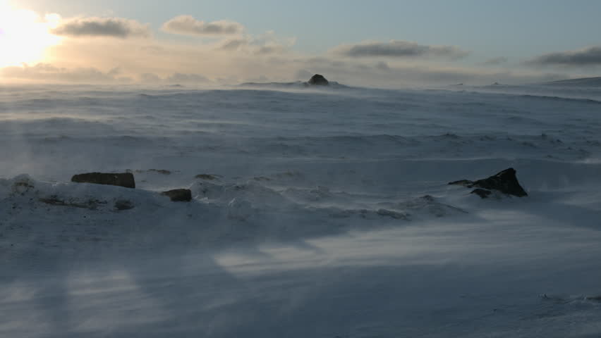 Blowing snow in the sun across a rocky field in west Iceland.