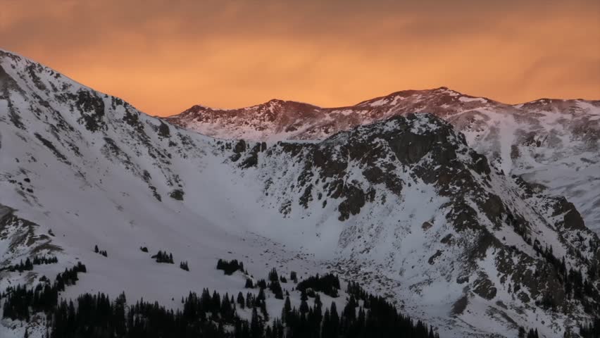 Last light winter solstice December Rocky Mountains golden hour aerial drone Colorado Continental Divide Loveland Pass Herman Gulch Coon Hill vibrant sunset dusk rugged snowy peaks upward motion