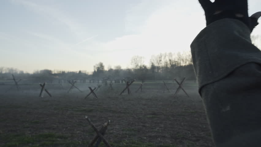 WWI scene of a German soldier emerging from a trench at dusk, hands raised, surrendering in no man