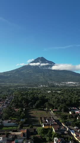 View of the Agua volcano during a drone flight over the colonial city of Antigua Guatemala. Aerial shot.