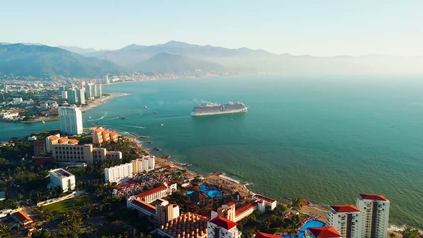 Cruise ship sailing near puerto vallarta coast during a beautiful sunset