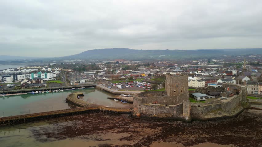Ultra wide aerial shot of Carrickfergus Castle in Northern Ireland. The camera advances, showing the castle, marina and town. Produced in 4K, 60FPS and in Rec709 colour.