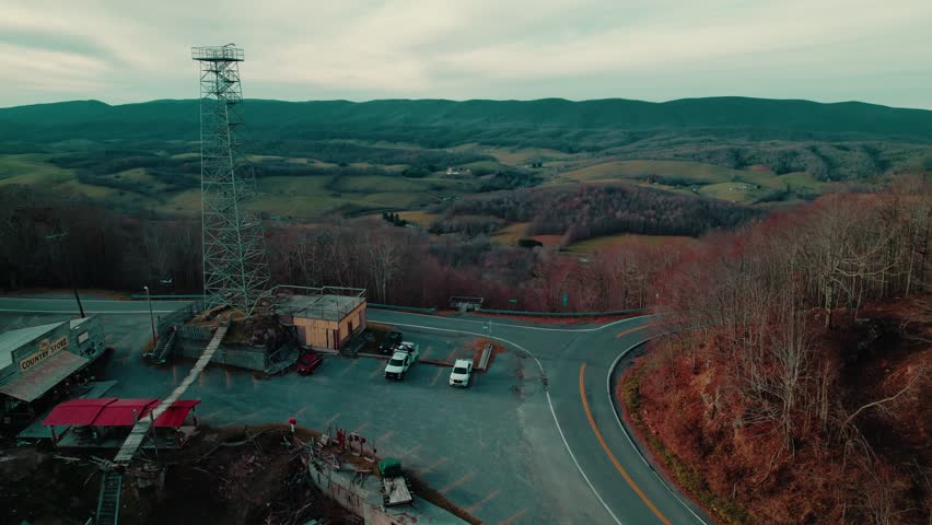 A rural mountaintop intersection with a historic country store and steel tower, offering panoramic farmland views and quiet Appalachian charm.