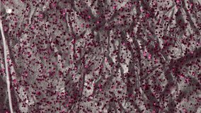 Viscous liquid with pink glitter particles flows down reflective material. 4k background - Powered by Shutterstock - Get 15% off with code: PIKWIZARD15