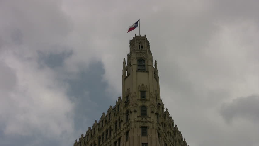 Video of downtown San Antonio Texas. Historic Emily Morgan Hotel with Texas flag on decorative tower. Next to Alamo. Carved stone facade. Proud Texas independence. 