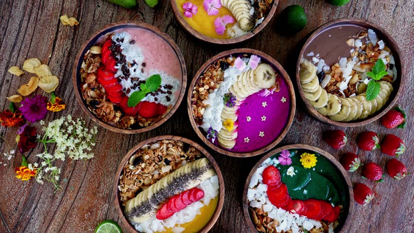 Fresh Bowls of Healthy Smoothie with Ripe Fruits and Juicy Berry on Beautiful Wood Table Close Up. Concept of Summer Meal of Raw Banana and Acai Mash. Top View on Strawberry Muesli and Coconut Flakes
