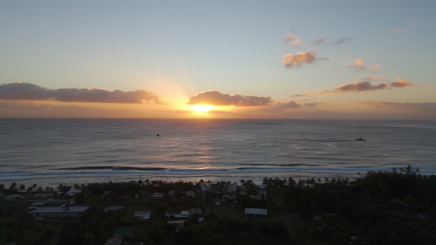 Drone shot of a sunrise over the tropical paradise beach in Rarotonga, Cook Islands.