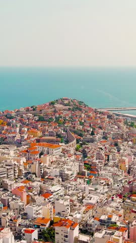 Vertical video. Kavala, Greece. Kavala Fortress and Aqueduct. The ferry leaves the port. Historic city center. Summer, Aerial View. Rich colors