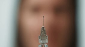 Doctor Holding a Syringe with Droplets Falling from the Needle Close-up in a Medical Scene. High quality 4k footage - Powered by Shutterstock - Get 15% off with code: PIKWIZARD15