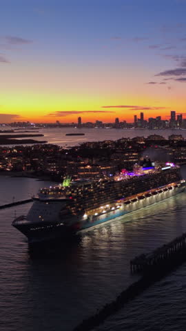 Cinematic drone shot of Miami vibrant skyline at sunset twilight with majestic ocean cruise liner departing for an unforgettable, luxurious holiday getaway amidst the citys distinctive coastal beauty