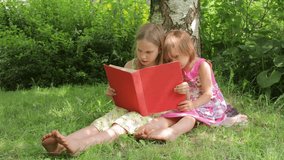 Two young girls sit closely together under a birch tree in a sunny garden, reading a red book and sharing a peaceful moment of connection and learning on a warm summer day - Powered by Shutterstock - Get 15% off with code: PIKWIZARD15