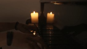 Pianist playing on the black grand piano with candle on concert stage in darkness, close up shot of hands on keys, isolated on studio background. Slow motion. - Powered by Shutterstock - Get 15% off with code: PIKWIZARD15