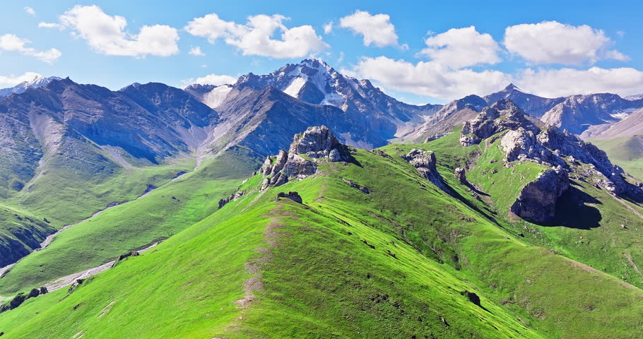 Mountain peak and green hillside under a cloudy sky. Summer landscape.