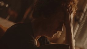 Sad young man sitting in softly lit room, hugging pillow and emotionally crying, feeling sorrow and vulnerability. Close-up, dutch angle shot - Powered by Shutterstock - Get 15% off with code: PIKWIZARD15