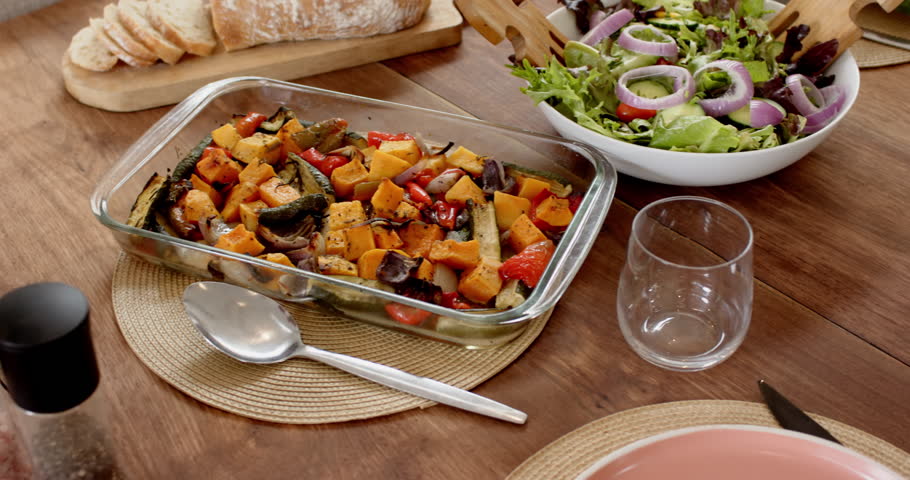 Fresh salad with red onions and roasted vegetables on wooden dining table. healthy, organic, food, vegetarian, vegan, meal